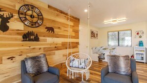 A cozy room with a wooden wall, two blue armchairs, a hanging chair, and a coffee station. - Peaceful Hillside Home with 3BD:2BTH & 30 Mins to Yosemite (Oakhurst)