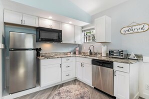 Een koelkast, een magnetron, een kookplaat, een vaatwasser