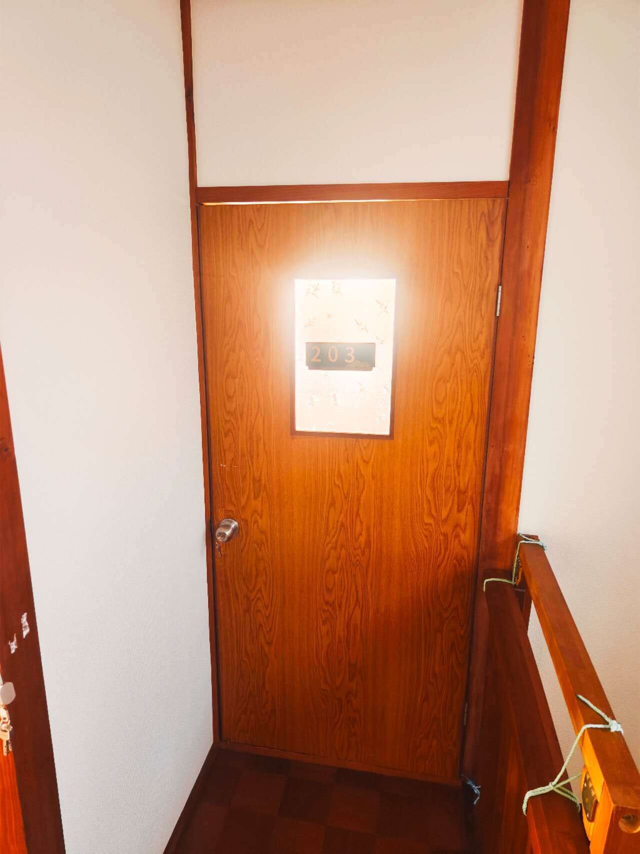 A wooden door with a digital display showing the number 203.