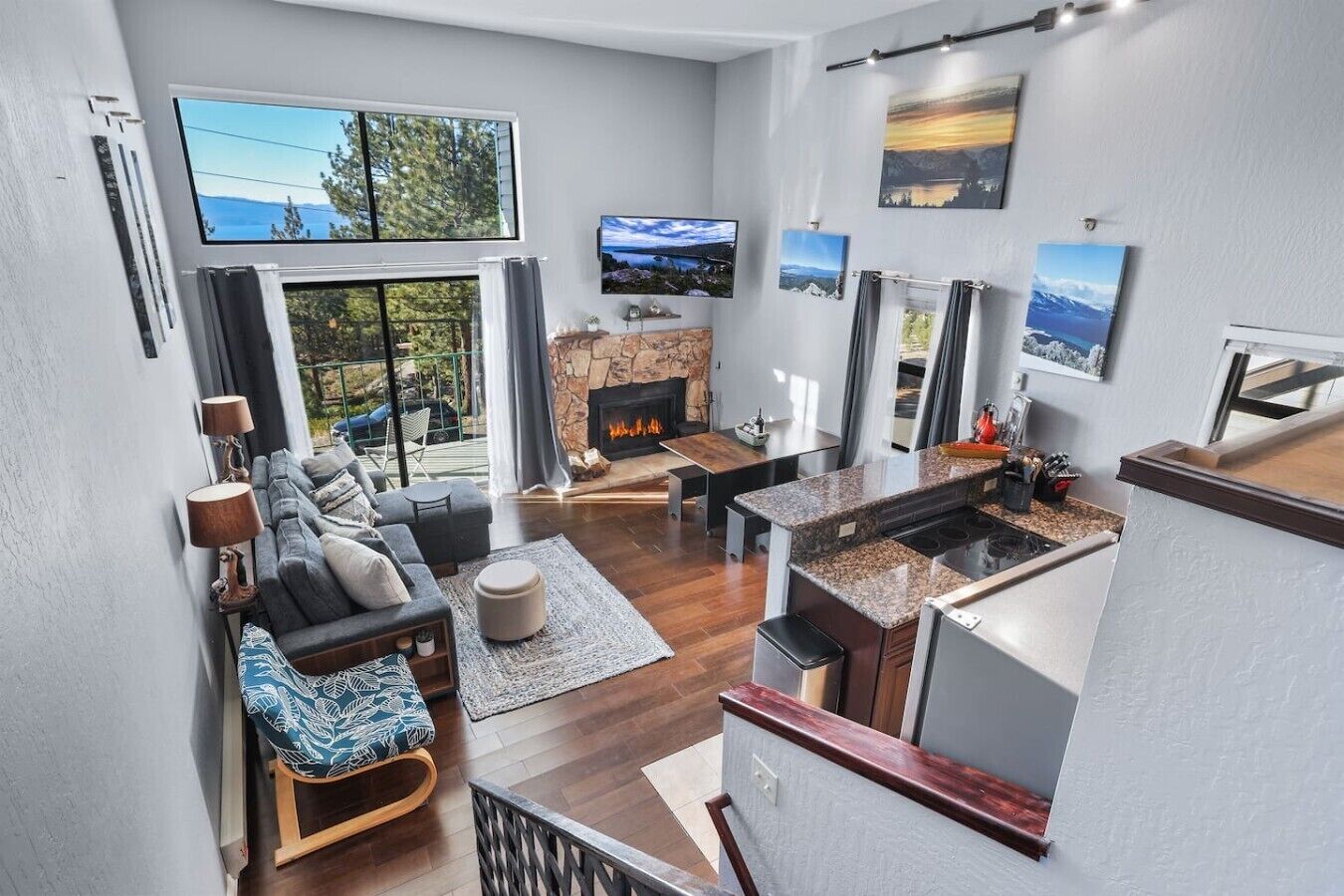 A modern living room with a fireplace, a dining area, and a kitchen with a stone countertop.