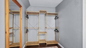 A room with a built-in wooden shelving unit with multiple compartments and hooks.