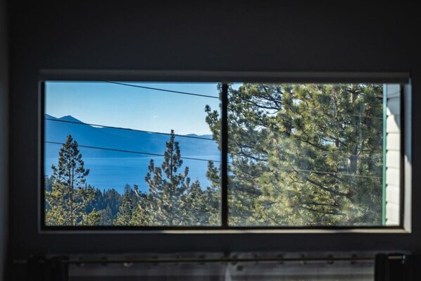 A window with a view of a mountain and trees.