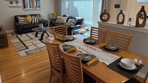 A dining area with a wooden table set for four, surrounded by wooden chairs. - 5BR Family home Near O’Hare, Easy Airport & Downtown Access, Garage Parking.  (Chicago)