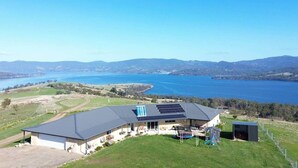 A house with a large roof area equipped with solar panels, a swimming pool, and a fenced yard. - Bruny Horizon - Where the Country meets the Sea (North Bruny)