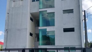 Un edificio moderno con fachada de vidrio y un coche estacionado adelante.