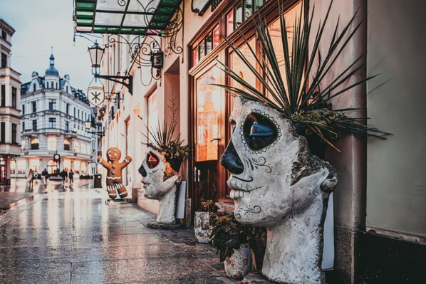 A street with buildings, a gingerbread man statue, and a large face sculpture. - Family Loft With Mezzanine Old Town (Torun)