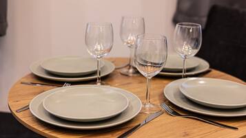 A table set with plates, cutlery, and wine glasses.