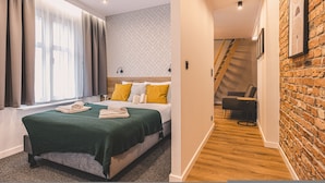 Une chambre d’hôtel moderne avec un grand lit, une couverture verte et une vue sur la ville.