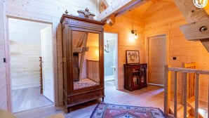 Ein Holzinterieur mit einem großen Spiegel, einem Holzkabinett und einem gemusterten Teppich.