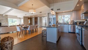 A modern kitchen with a central island, stainless steel appliances, and a dining area with a view. - New Listing Vast Red Rock Views 2 Master Suites - Panorama Landing (Sedona)