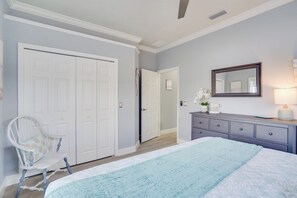 A bedroom with a bed, a dresser, a chair, and a closet. - Griffins' Island Getaway (Holmes Beach)