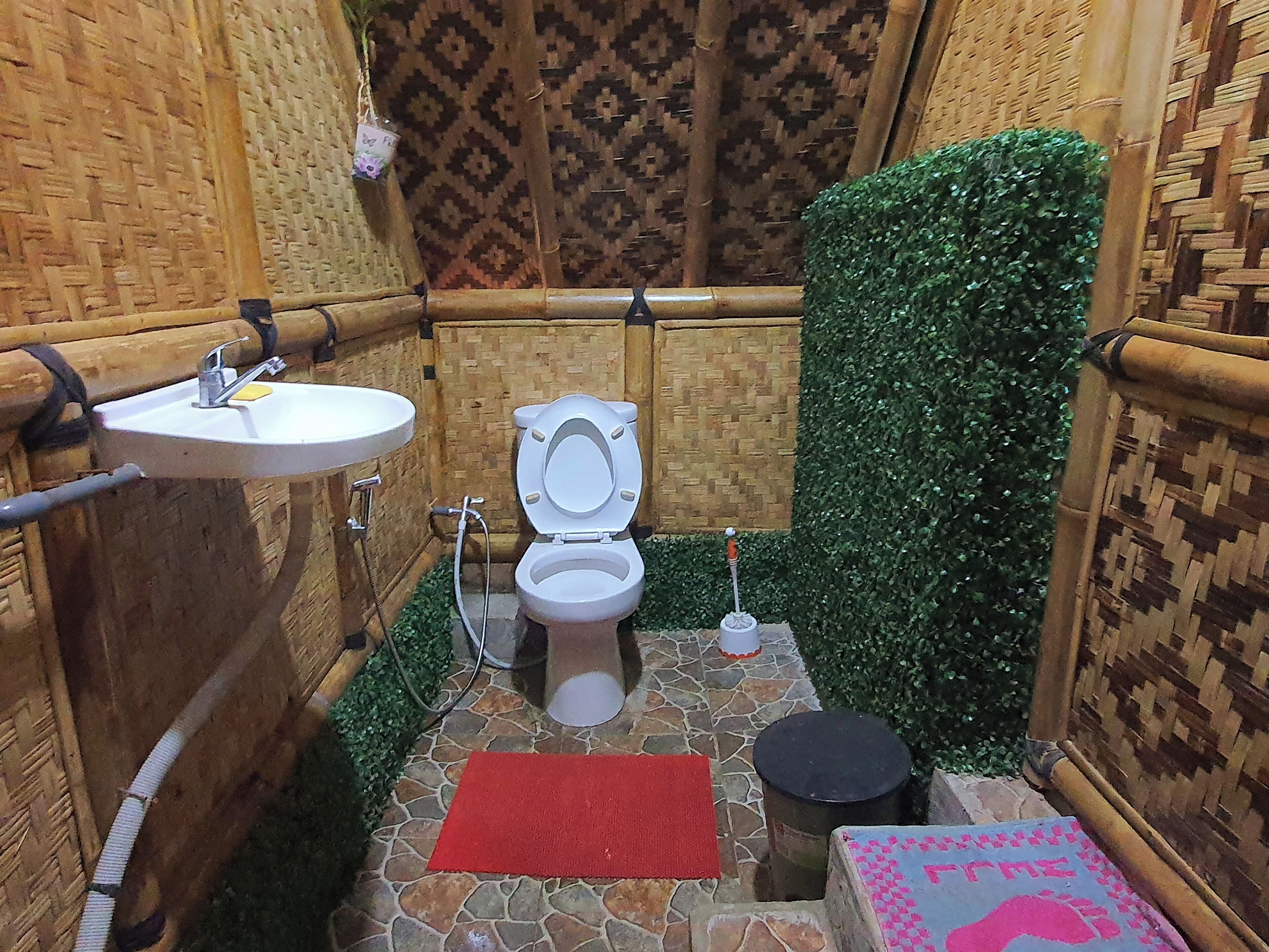 A bathroom with a white toilet, a sink, and a shower area.