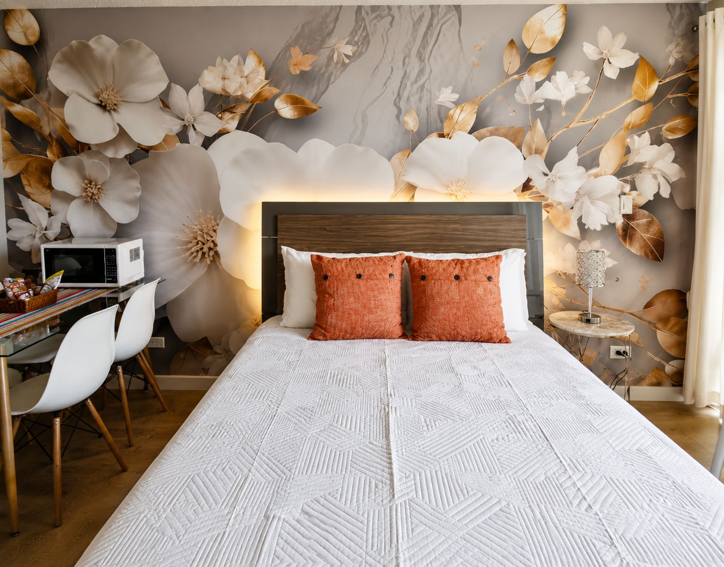 A bedroom with a bed, a desk, and a chair.