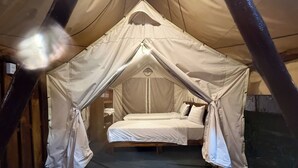 A tented room with a single bed, wooden flooring, and a mosquito net. - Cay Sao Beach Glamping Phu Quoc (Phu Quoc)