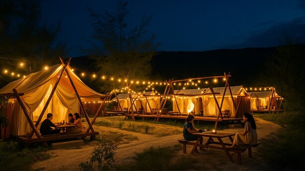 A campsite with multiple tents connected by a wooden structure, string lights, and picnic tables. - Cay Sao Beach Glamping Phu Quoc (Phu Quoc)