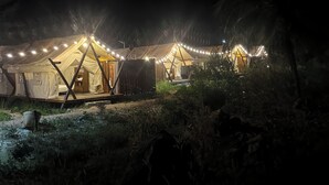 A series of tents with string lights, surrounded by vegetation. - Cay Sao Beach Glamping Phu Quoc (Phu Quoc)