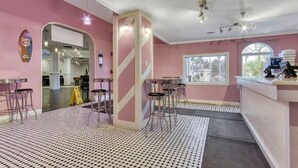 Zona bar con sgabelli, un bancone e vista dalla finestra.
