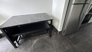 Eine Küche mit schwarzem Marmor-Arbeitsplatz, integriertem Backofen und dunklen Fliesen.