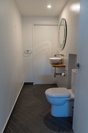 Chuveiro, toalhas de banho, sabonete, papel higiênico