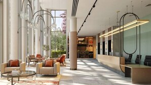 Eine geräumige Lobby mit moderner Möblierung, großen Fenstern und einer Rezeption.