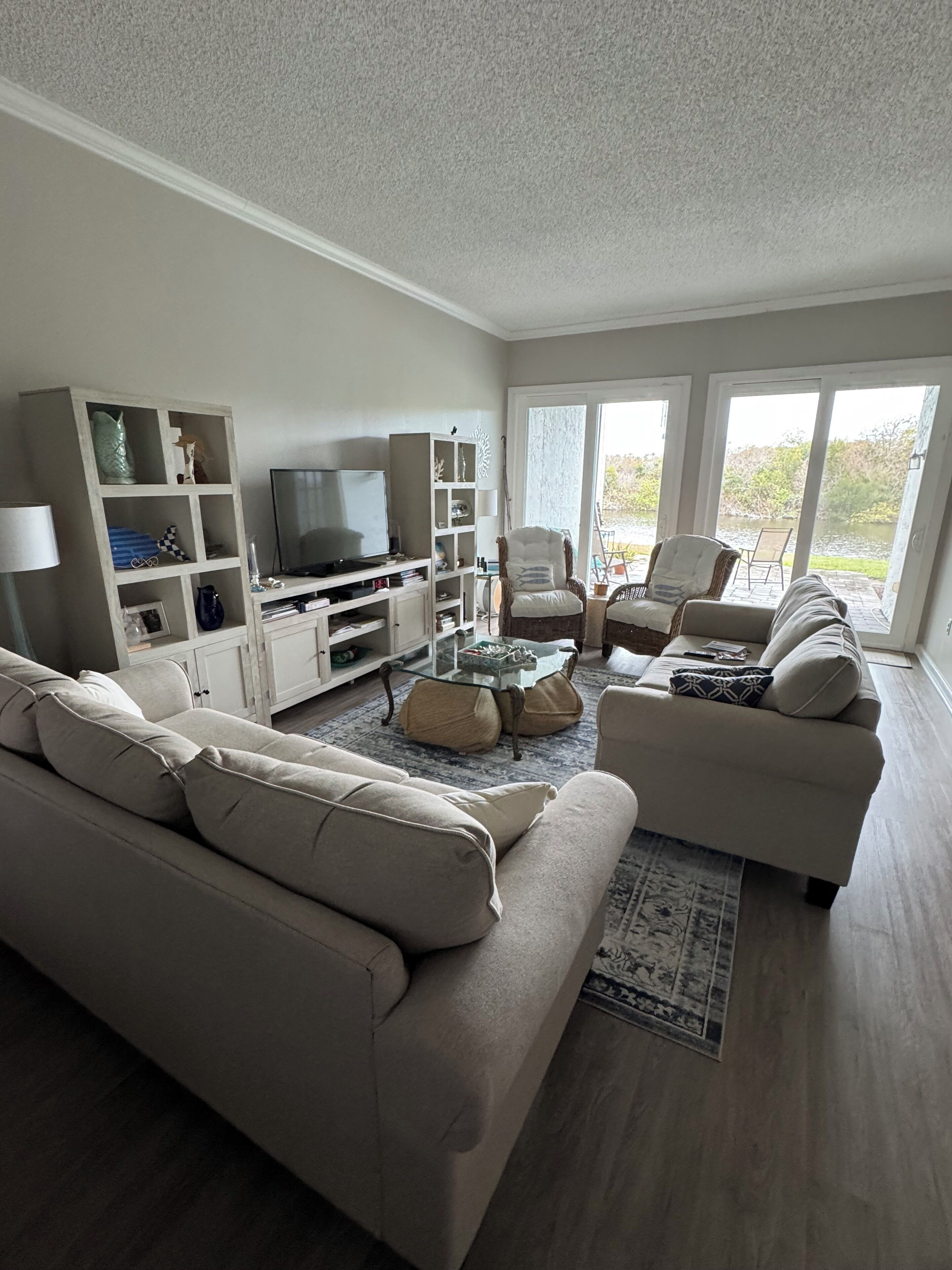A living room with a sofa, armchairs, a TV, and a bookshelf.