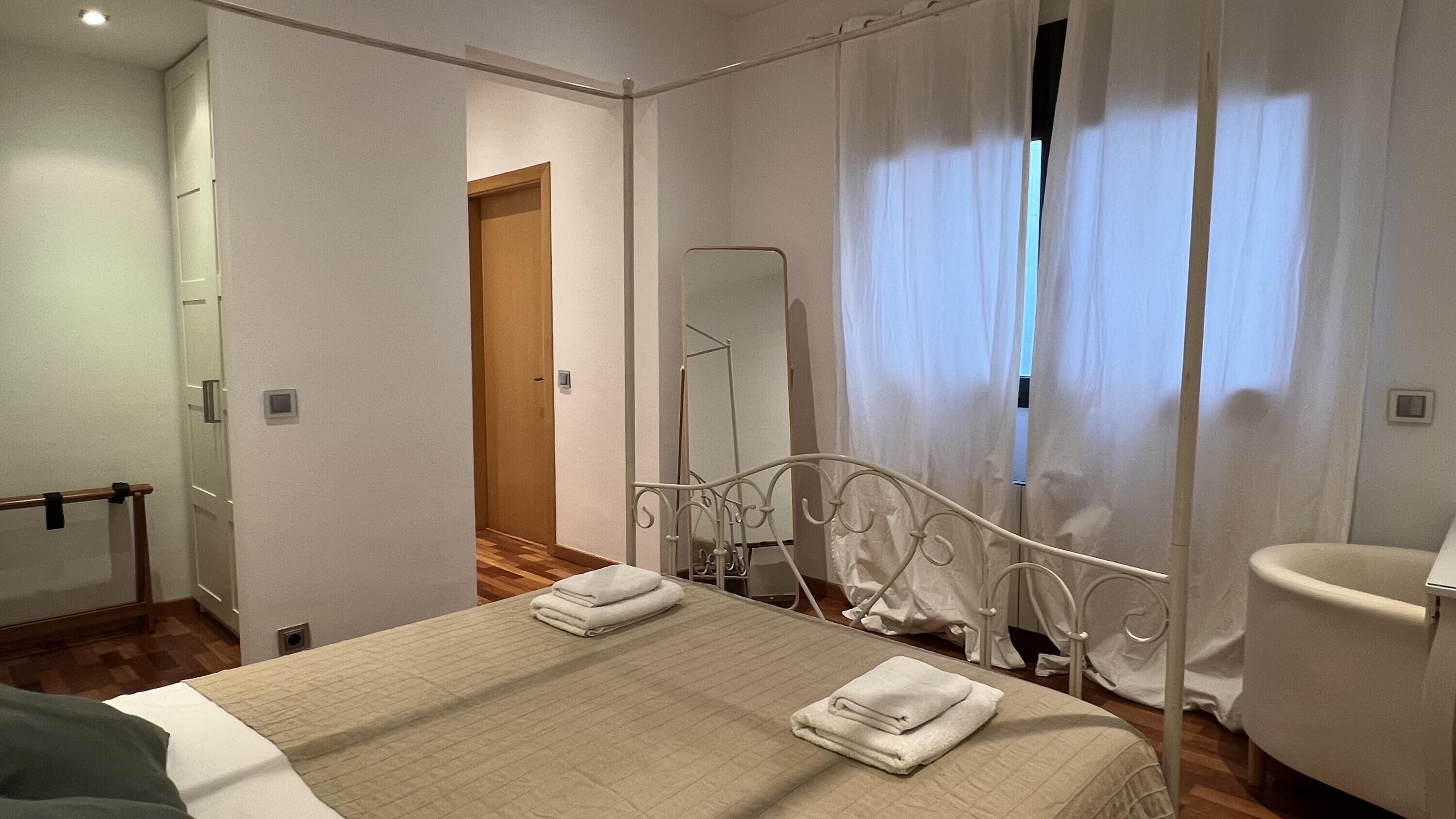 Habitació d'hotel amb llit, bany i mirall.