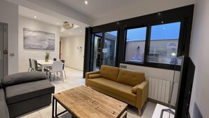 Ein modernes Wohnzimmer mit einer Couch, einem Couchtisch und einem Essbereich mit Stühlen und einem Tisch.