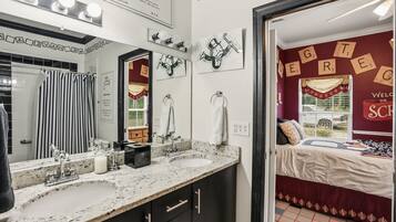 Une salle de bain avec un double lavabo, un miroir et un porte-serviettes.