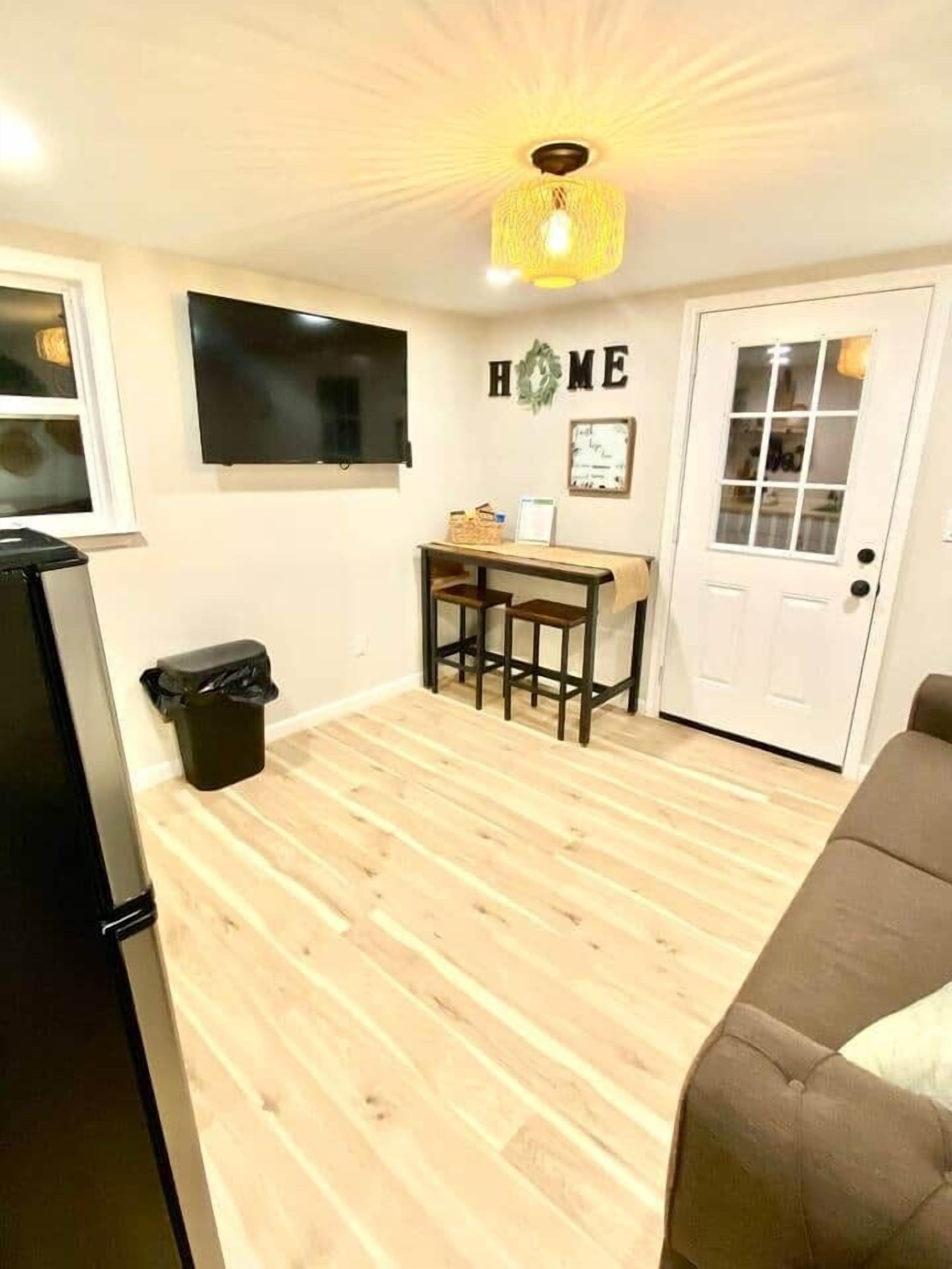 Een knus woongedeelte met een kitchenette, een eethoek en een bank.