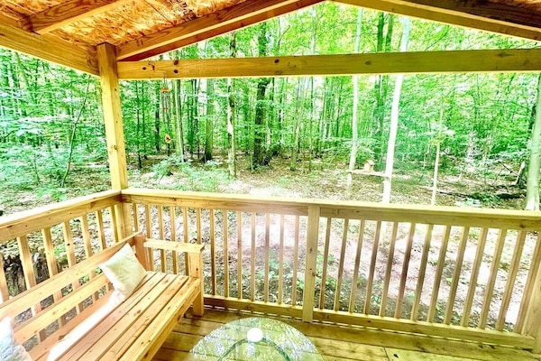 This picturesque porch offers a front-row seat to nature's theater. Surrounded by a choir of towering trees this view truly provides an idyllic panorama of the ever-changing, yet always beautiful, woodland canvas.