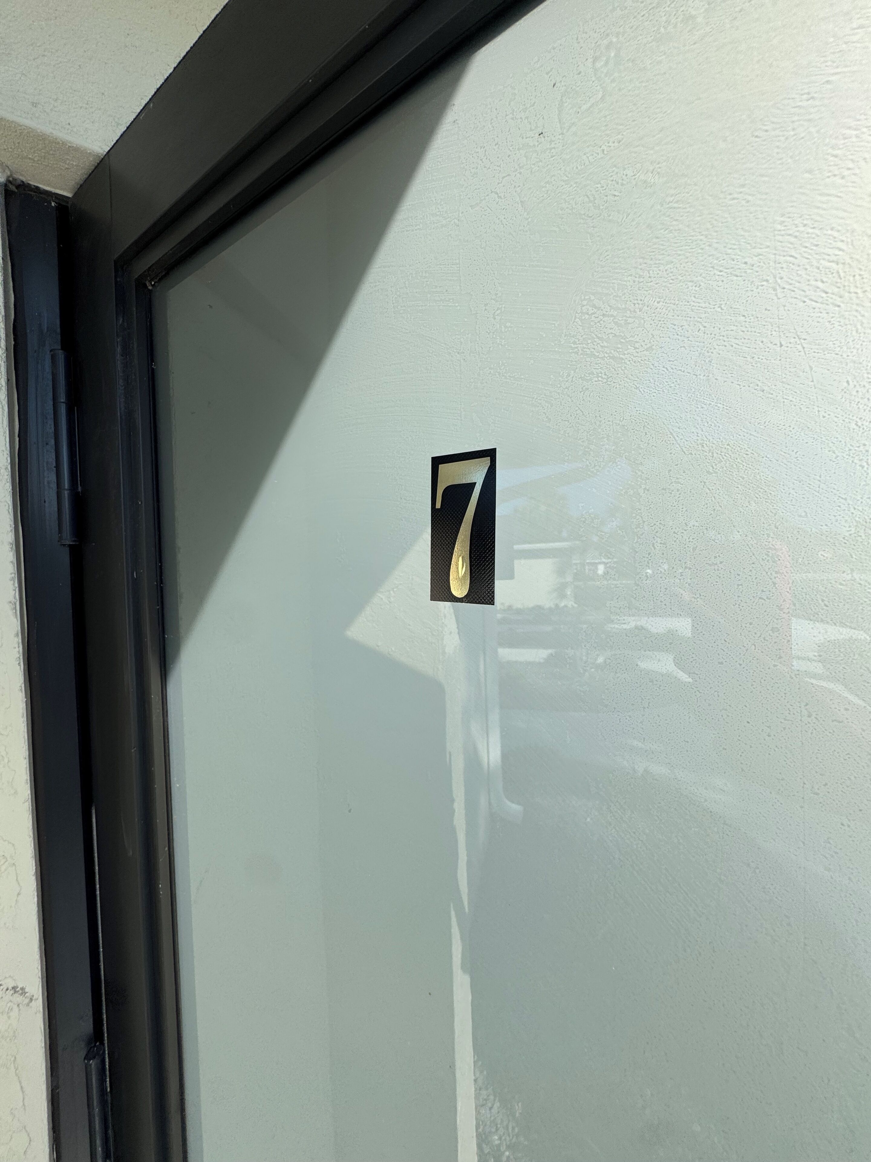 En glasdør med frostet overflade og et klistermærke med nummer 7.