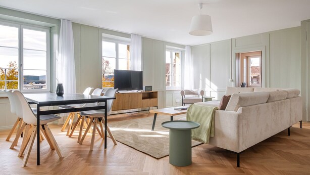 Un salon moderne comprenant un coin repas, un canapé et un téléviseur.