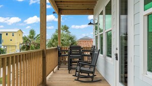 Une terrasse en bois avec des meubles d’extérieur, un espace abrité et une vue sur les bâtiments voisins.