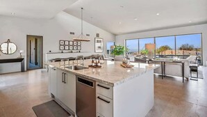 A spacious kitchen with a large island, modern appliances, and a view of the outdoors.