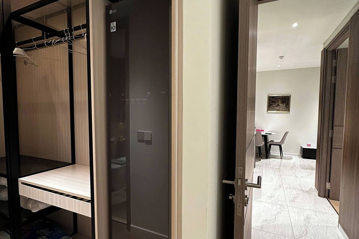 A modern bedroom with a built-in wardrobe, a bed, and a small seating area.