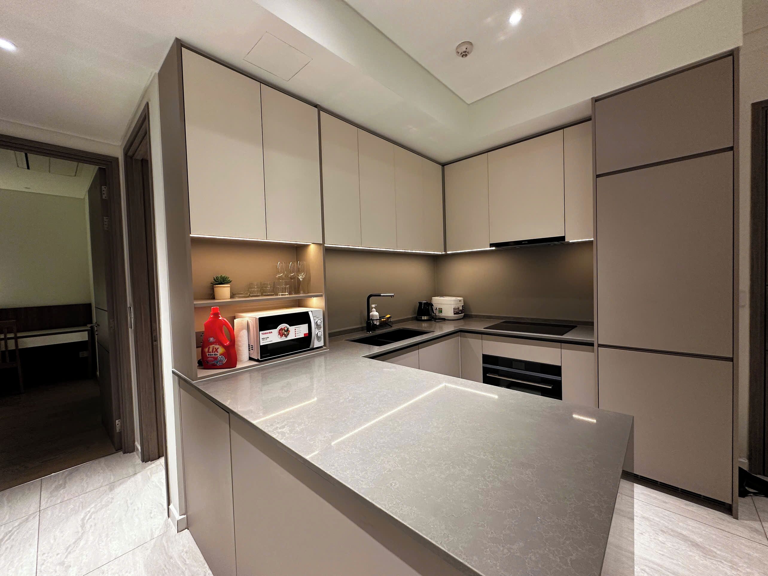 Uma cozinha moderna com uma ilha grande, eletrodomésticos embutidos e design minimalista.