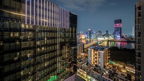 A modern building with reflective glass windows and a prominent illuminated facade. - Nice Apartments at Metropole Thu Thiem (Ho Chi Minh City)