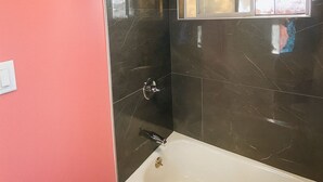 A bathroom with a bathtub, a shower, and a window. - Casa Valentine Inn - Los Angeles (Los Angeles)