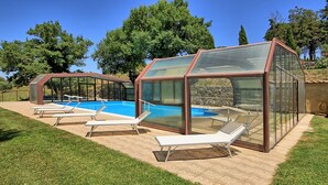 Ein Poolbereich mit gläsernen Liegestühlen und einem klaren, blauen Pool.