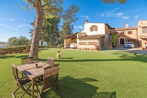 A villa with a patio, outdoor seating, and a view of the sea.