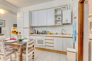 A modern kitchen with white cabinets, a built-in oven, and a sink. - Casa Lilly Sanremo La Pigna Old Town Hideaway, Sanremo, Italy (Sanremo)