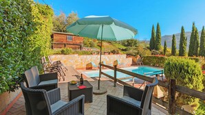 An outdoor patio with wicker furniture, a pool, and a large umbrella. - Comfortable House Private Pool & View for 6, Pescia, Italy (Pescia)