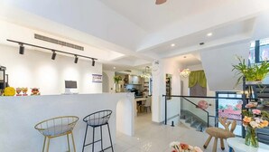 Cozinha moderna com ilha central, área de jantar com mesa redonda e escada que leva a um andar superior.