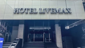 Entrada de l'Hotel Livemax, amb una façana moderna i una escala que condueix a l'entrada.