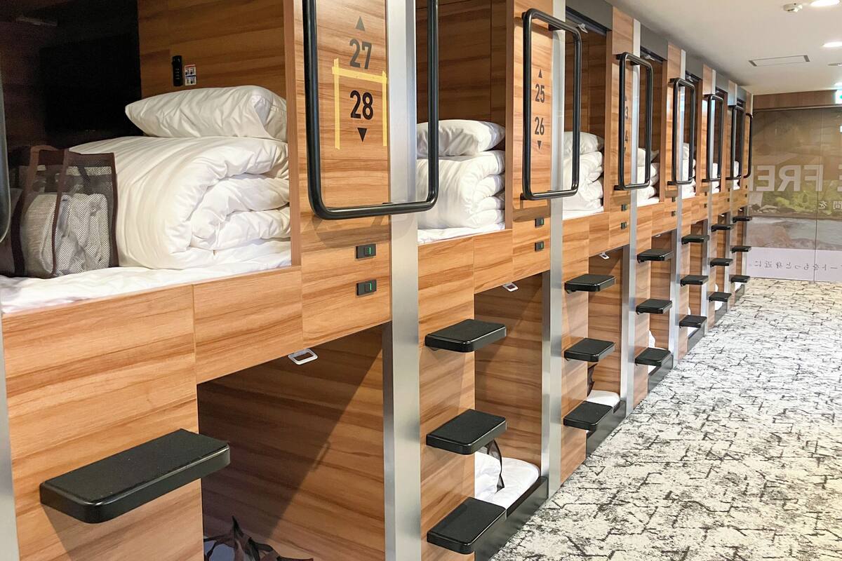 Una fila de literas con números individuales, paneles de madera y compartimentos de almacenamiento integrados.