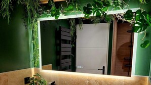 A bathroom with two large stone sinks, a mirror, and green plants. - Tropical escape Suite Jungle Room (Thiers)