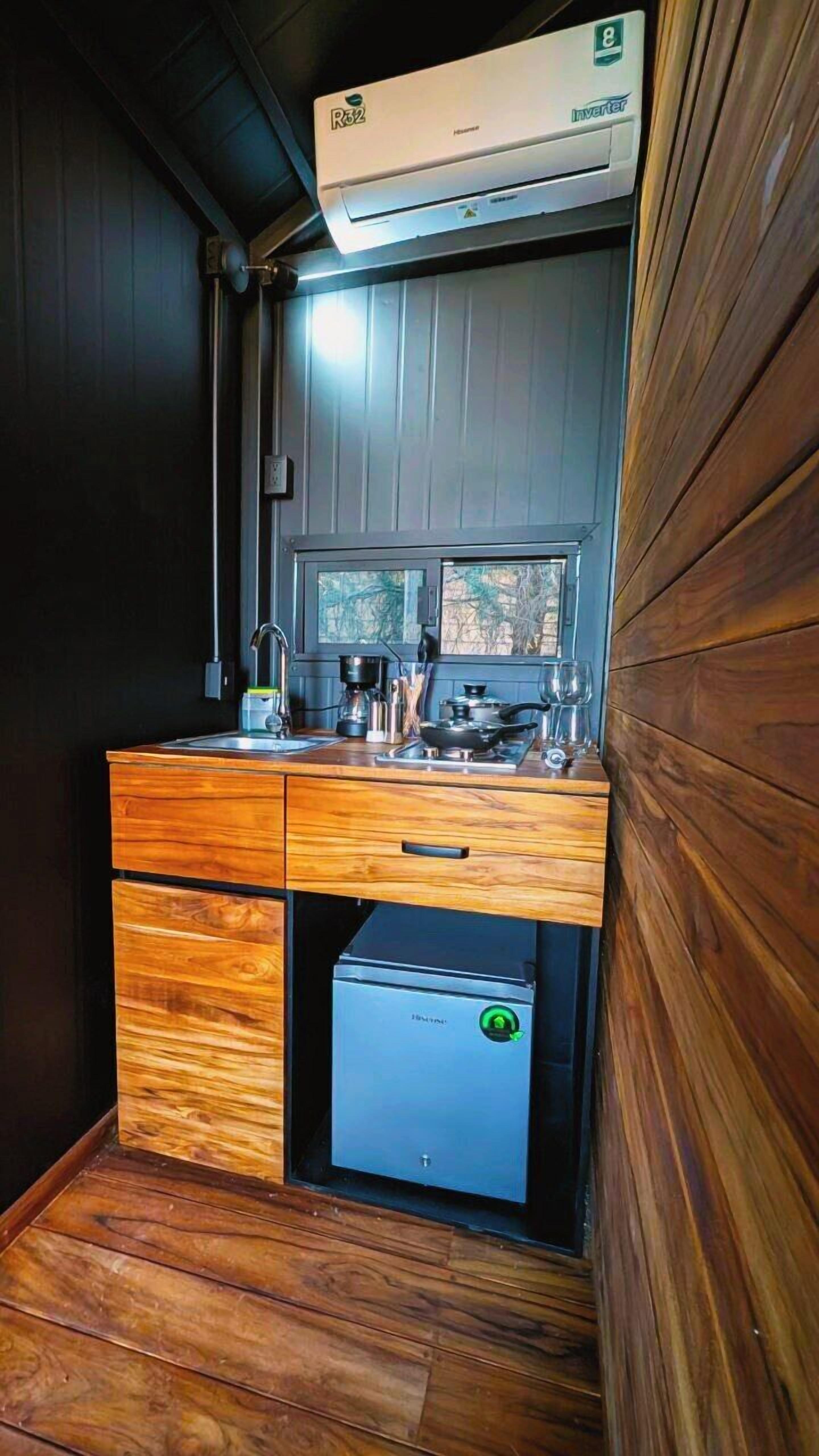 Una cocina compacta con estufa integrada, un lavabo y un refrigerador pequeño.