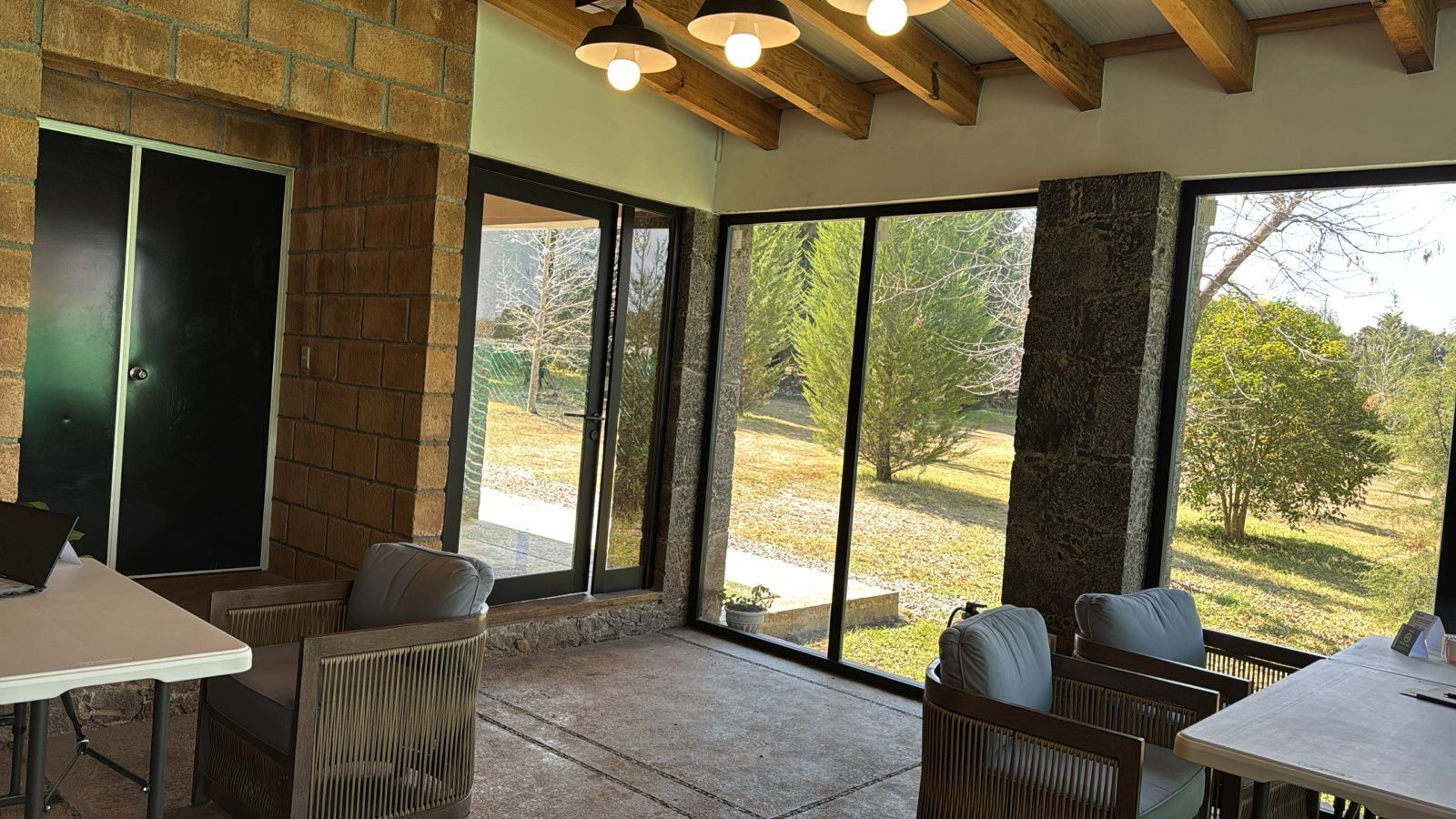 A patio area with outdoor seating, large windows, and a stone fireplace.