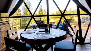 An interior view of a triangular tent with a table and chairs set up inside.