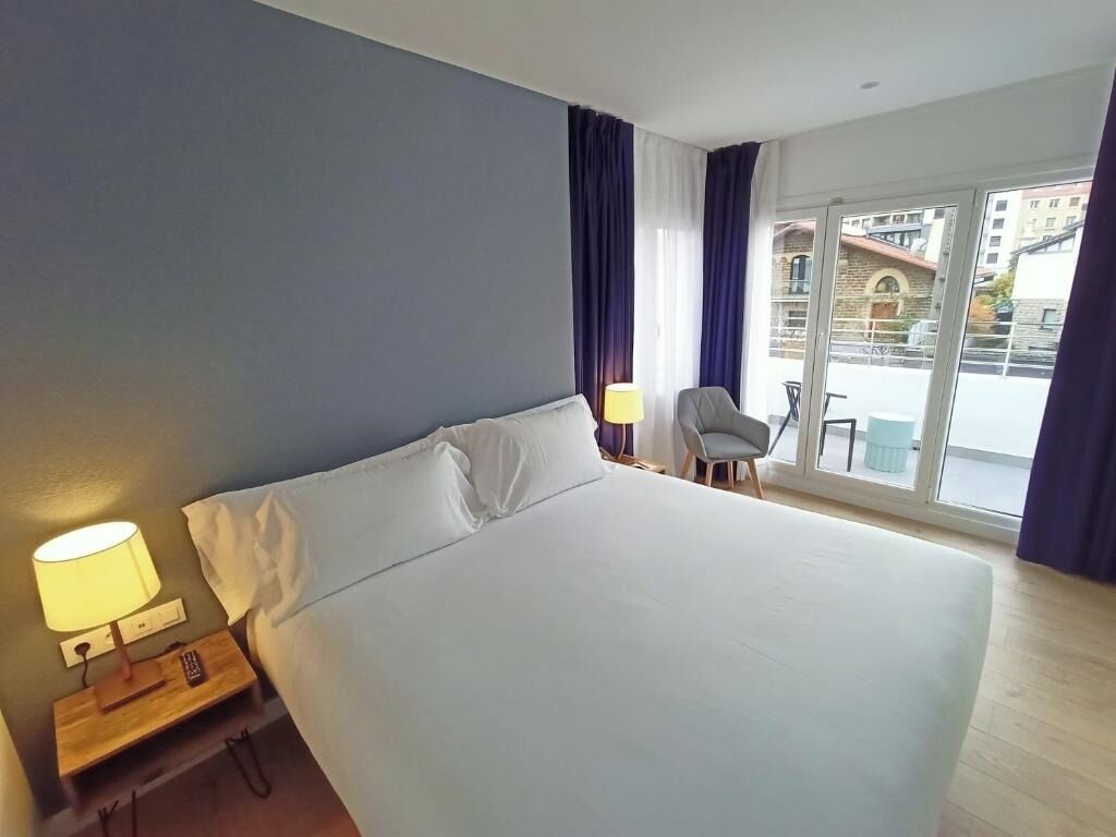 Unwind in a sunlit king bed with balcony breeze.